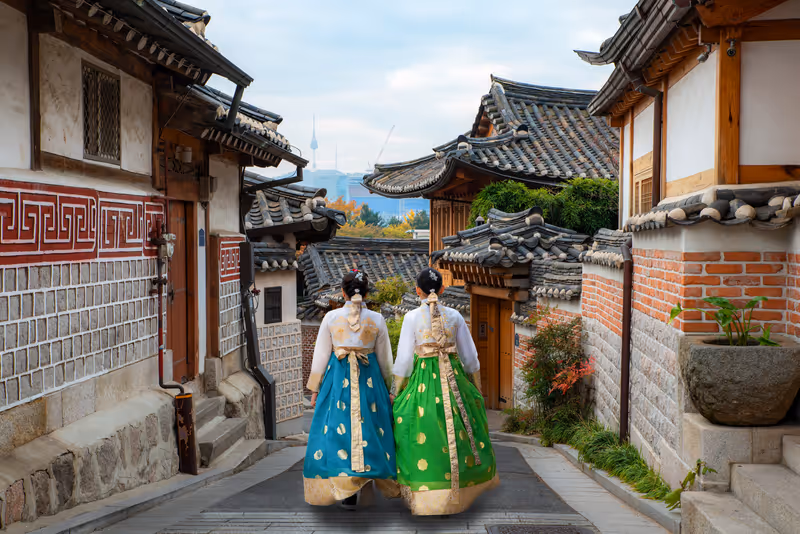 Women wearing hanbok stroll through the traditional tea houses of Bukchon in Seoul