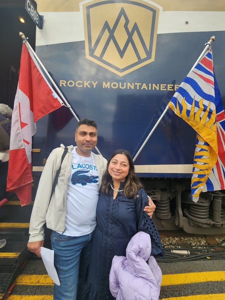 Travellers with Canadian and BC flags in front of the Rocky Mountaineer